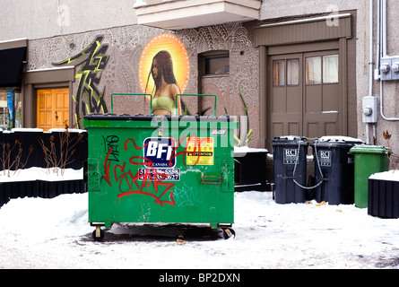 Müllcontainer und recycling-Container auf den Vorgarten eines Montreal-Gebäudes mit einem aufwendigen Murale Gemälde geschmückt. Stockfoto