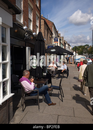 Café-Kultur, drei Männer genießen den Sonnenschein an Tischen auf dem Bürgersteig in Yarn High Street Stockfoto
