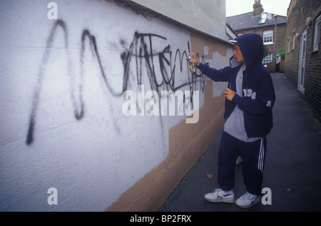 Teenager, die eine Wand mit Graffiti Verunstaltung Stockfoto
