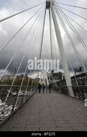 eine London-Stadt-Hängebrücke über die Themse in einem Regenschauer Stockfoto