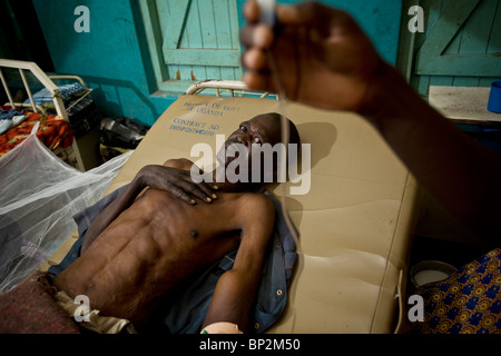 Ein ausgemergelten Mann liegt in einem Krankenhausbett in Amuria, NE Uganda, Ostafrika. Stockfoto