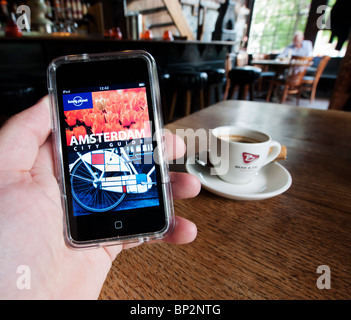 Lesen e-Book Reiseführer für Amsterdam mit Tasse Kaffee in den Niederlanden Amsterdam Stockfoto