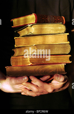 Hände halten einen Stapel alter Bücher Stockfoto