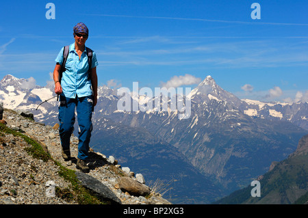 Weibliche Wanderer Wandern auf einem schmalen Bergweg hoch über dem Rhonetal in die Walliser Alpen, Wallis, Schweiz Stockfoto