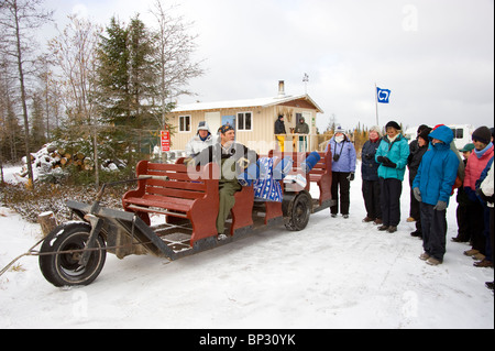 Dave Daley sitzt auf einem fahrbaren Hundeschlitten im Gespräch mit einer Reisegruppe in Churchill, Kanada Stockfoto