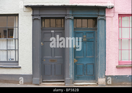 Schmuddeligen grau und blau aus Holz getäfelten vorderen Türen Nr. 92 91 mit Griff Briefkasten Giebel Architrave vom historischen Bürgerhäusern in UK Stockfoto