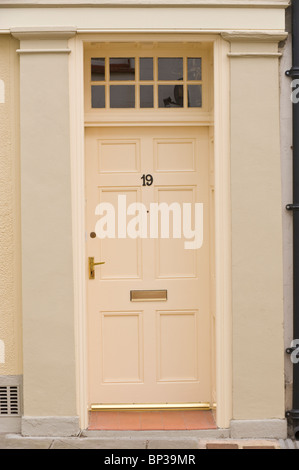Bemalte Creme farbigen Holz getäfelten Haustür Nr. 19 mit Messing Griff Briefkasten und Oberlicht antiken Stadthauses in UK Stockfoto