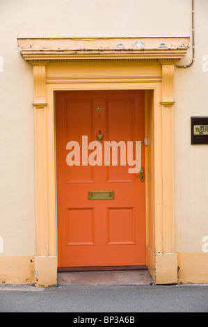 Orange lackiert Holz getäfelten Haustür Nr. 96 mit Messing-Briefkasten und flachen Giebel und Architrave vom Stadthaus in UK Stockfoto