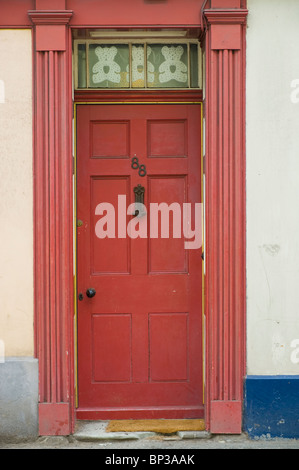 Scruffy rot Holz getäfelten Haustür Nr. 88 mit Briefkasten und Knopf des Hauses in UK Stockfoto