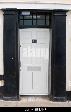 Weiß gestrichene moderne Holz getäfelten Haustür Nr. 21 mit Griff Briefkasten und schwarzen Surround antiken Stadthauses in UK Stockfoto