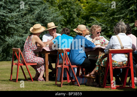 Menschen sitzen und plaudern, während Sie eine Tasse Tee an einem Dorffest in England zu genießen. Stockfoto