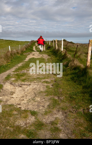 Mann mit seinem Hund genießen den Küstenpfad Stockfoto