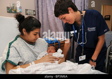 Eine Mutter und ihren 2 Tage alten Säugling mit einem Krankenschwesterschülerin in einem Krankenhaus. Stockfoto