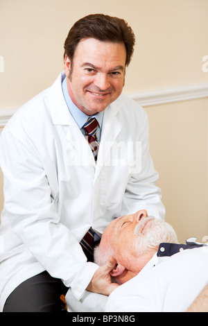 Gut aussehend, lächelnden Chiropraktiker Anpassung eines älteren Mannes Hals. Stockfoto