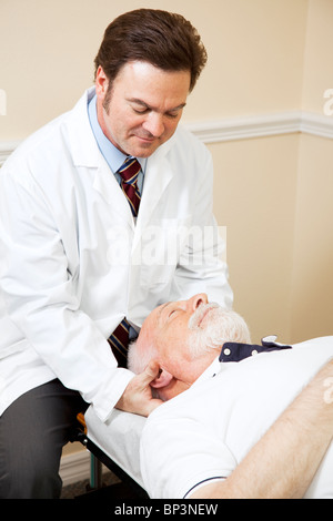 Fürsorgliche Chiropraktiker passt eines älteren Mannes Hals. Stockfoto