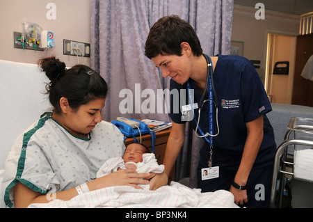 Eine Mutter und ihren 2 Tage alten Säugling mit einem Krankenschwesterschülerin in einem Krankenhaus. Stockfoto