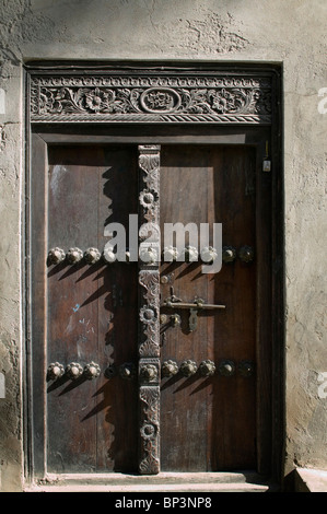 Afrika, Tansania, Zanzibar, Stone Town, morgen Sonne Licht kunstvoll geschnitzten Holztür in engen Gasse Stockfoto