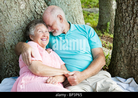 Älteres Paar in Liebe. Er ist etwas komisch ihr ins Ohr flüstern. Stockfoto