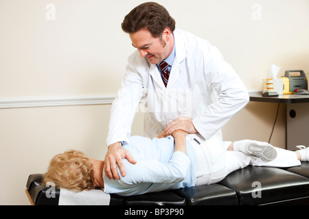 Chiropraktiker, eine ältere Frau Wirbelsäule sanft anpassen. Stockfoto