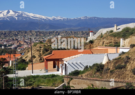 Höhlenwohnungen im Quartier Höhlenwohnungen mit Blick auf den Schnee bedeckt Berge, Guadix, Provinz Granada, Andalusien, Spanien. Stockfoto