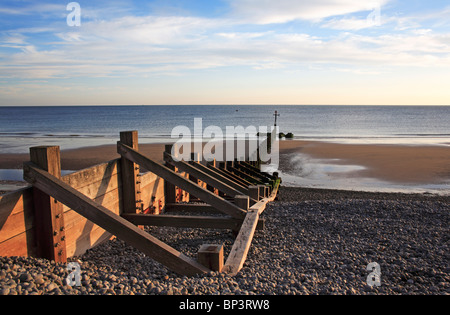 Hölzernen Wellenbrecher erstreckt sich über den Strand bei Ebbe in Sheringham, Norfolk, England, Vereinigtes Königreich. Stockfoto