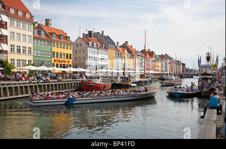 Nyhavn Kanal voller manövrieren Tour Kanalboote und überfüllte Restaurants direkt am Wasser an einem sehr anstrengenden Sommertag Stockfoto