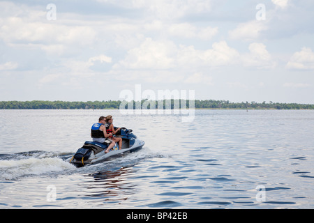 Lake George, FL - Mai 2010 - Mann sitzt hinter Autofahrerin eine Wassermotorräder auf Lake George in Zentral-Florida Stockfoto