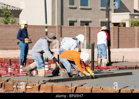 Eine Crew von Bauarbeitern Gießen Betonfundament für ein neues Haus. Stockfoto