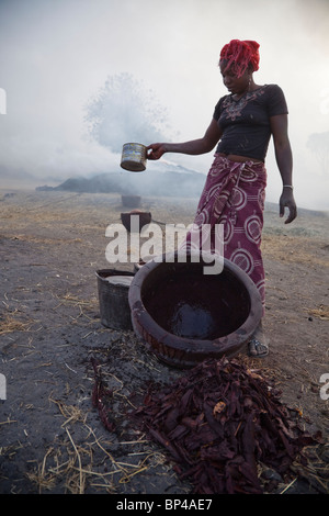 In Kalabougou in der Nähe von Segou, Mali bereitet eine Frau Farbstoffe für Keramik. Stockfoto