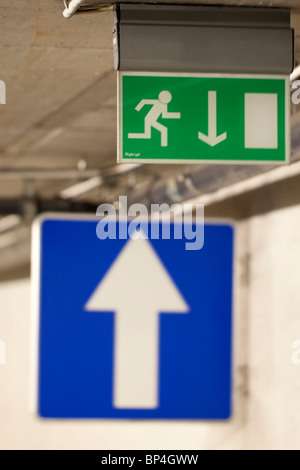 Blaues Schild mit einem weißen Pfeil nach oben und ein Notausgangsschild mit Pfeil nach unten Stockfoto