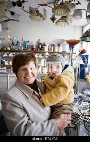 Frau mit ihrem Enkelkind in einem kleinen Elektronik-Geschäft. Zwolen Polen. Stockfoto