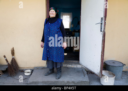 Alter Bauer vor ihrem alten Haus. Heute lebt sie in einem neueren Bauernhaus. Gmina Przylek, Zwolen Grafschaft, Polen. Stockfoto