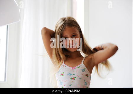 Mädchen von acht Jahren ihre Haare zu kämmen. Stockfoto