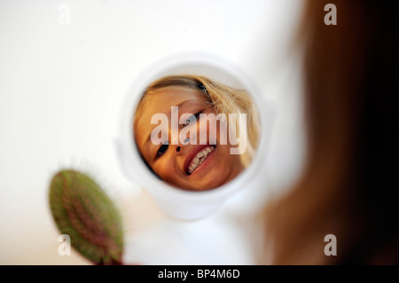 Mädchen von acht Jahren ihre Haare zu kämmen. Stockfoto