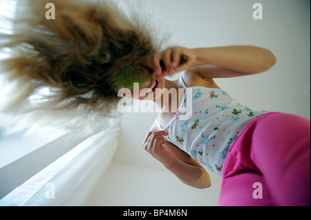 Mädchen von acht Jahren ihre Haare zu kämmen. Stockfoto