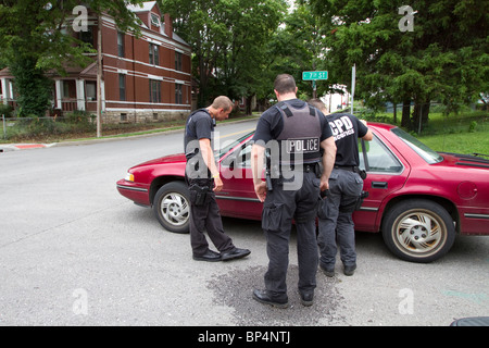 Polizisten aus taktischen Team im Gespräch mit einer Person gefunden, schlafen in einem Fahrzeug in einem Knotenpunkt. Kansas City, MO, PD. Stockfoto