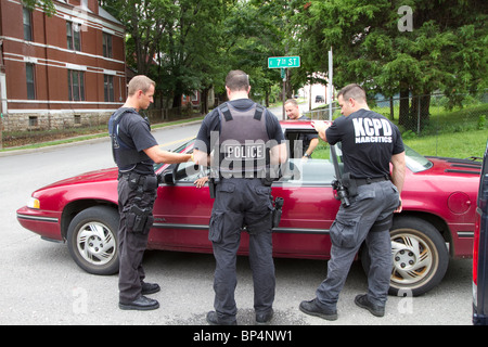 Polizisten aus taktischen Team im Gespräch mit einer Person gefunden, schlafen in einem Fahrzeug in einem Knotenpunkt. Kansas City, MO, PD. Stockfoto