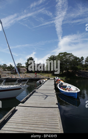 Segeln und hölzerne Ruderboote angedockt an Rödhamn in den Schären in Lemland auf Insel Aland in Finnland Stockfoto