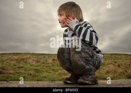 Kleiner Junge mit Schlamm bedeckt Stockfoto