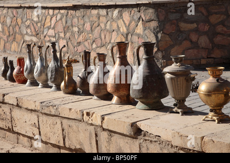 Eine Reihe von metallischen Gläsern entlang einer Wand in Bokhara-Markt in Usbekistan. Stockfoto