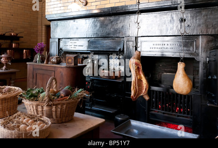 Cragside historisches Haus Northumberland UK - Innenraum - die Küche mit offenen Bereich und Rösten spucken Kleiderbügel Stockfoto