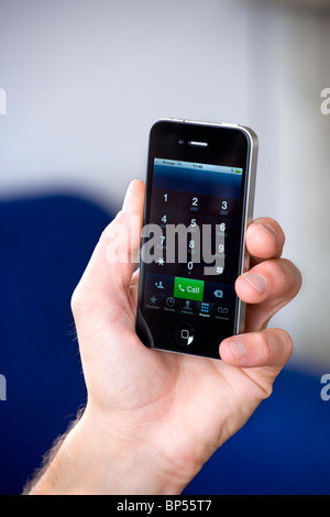 Apple Mac Iphone 4g in die Hand eines Mannes beim Wählvorgang stattfindet Stockfoto