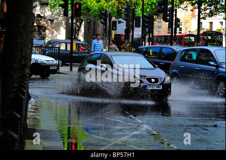 Fahrzeuge fahren durch Pfützen macht einen großen Sprung Stockfoto