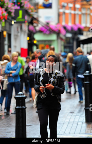 Mädchen hören Ipod in der Carnaby Street, London Stockfoto