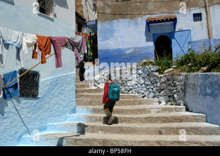 Marokkanischer Schuljunge Klettern Treppen, Treppen oder Treppen in der Altstadt, Medina oder dem historischen Viertel von Chefchaouen, Marokko Stockfoto