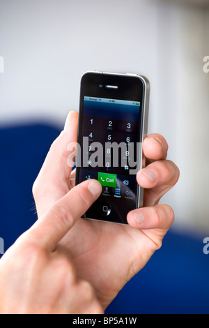 Apple Mac Iphone 4g in die Hand eines Mannes beim Wählvorgang stattfindet Stockfoto