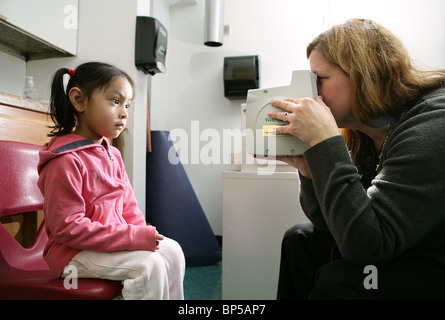 Ein Kind wird ihre Vision von einem Fachmann in einer Schule auf der Grundlage Gesundheitsprogramm in New Haven CT USA überprüfen Stockfoto