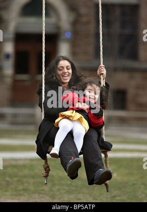 Eine Mutter und Tochter zum Lachen, als sie auf einem Seil schwingen an der Yale University in New Haven, CT, USA schwingen Stockfoto