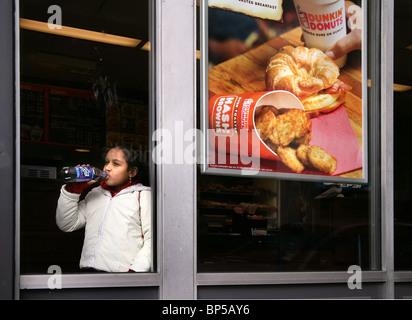 Ein junges Mädchen genießt eine Soda in der beliebten Nahrungskette "Dunkin Donuts" in New Haven CT USA Stockfoto