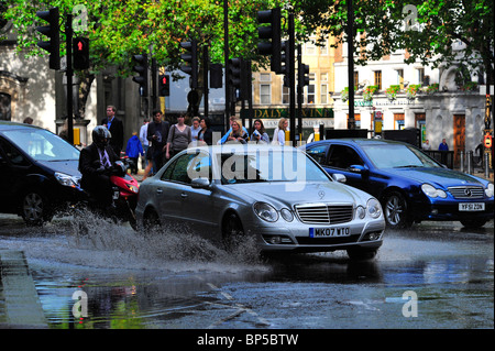 Fahrzeuge fahren durch Pfützen macht einen großen Sprung Stockfoto